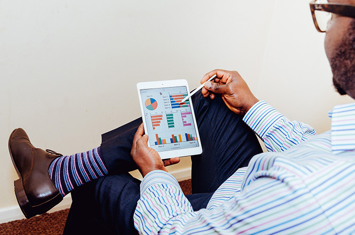 A man sitting and using an iPad with a pencil