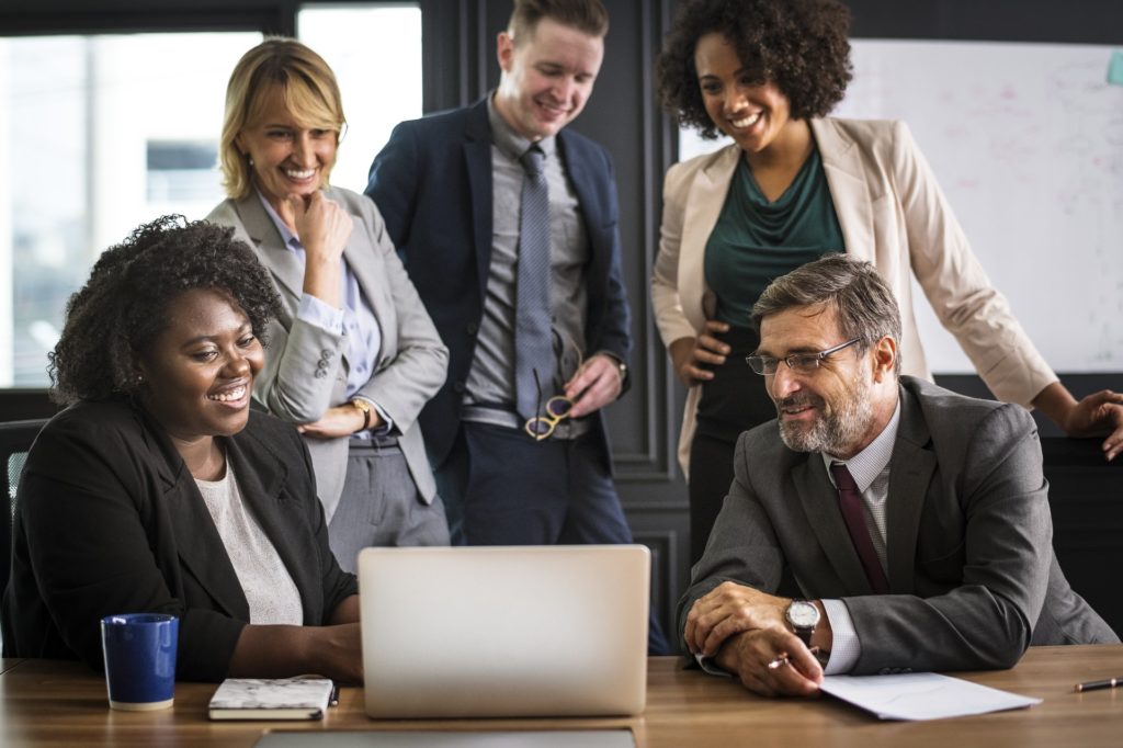 Some people smiling by watching at the laptop screen